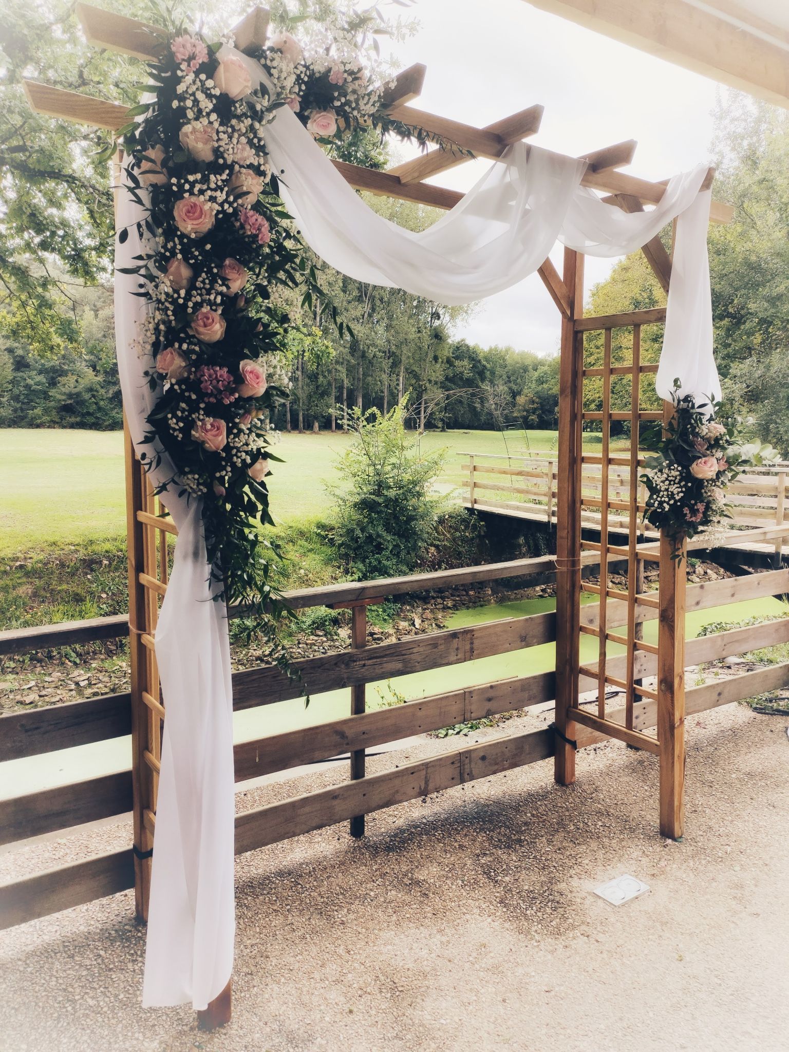 Mariage champetre arche fleurs bois voilage blanc